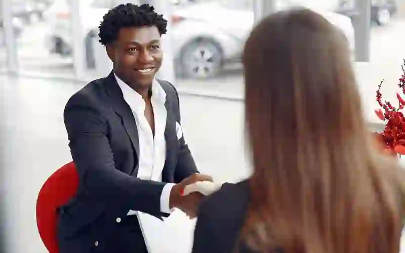 man in a suit shaking hands with a woman